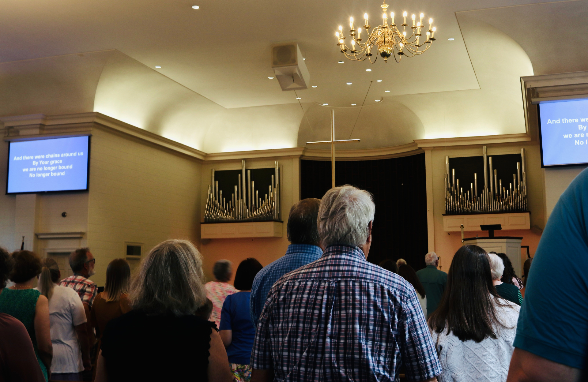 Welborne sanctuary during worship, with congregation facing the cross and organ pipes